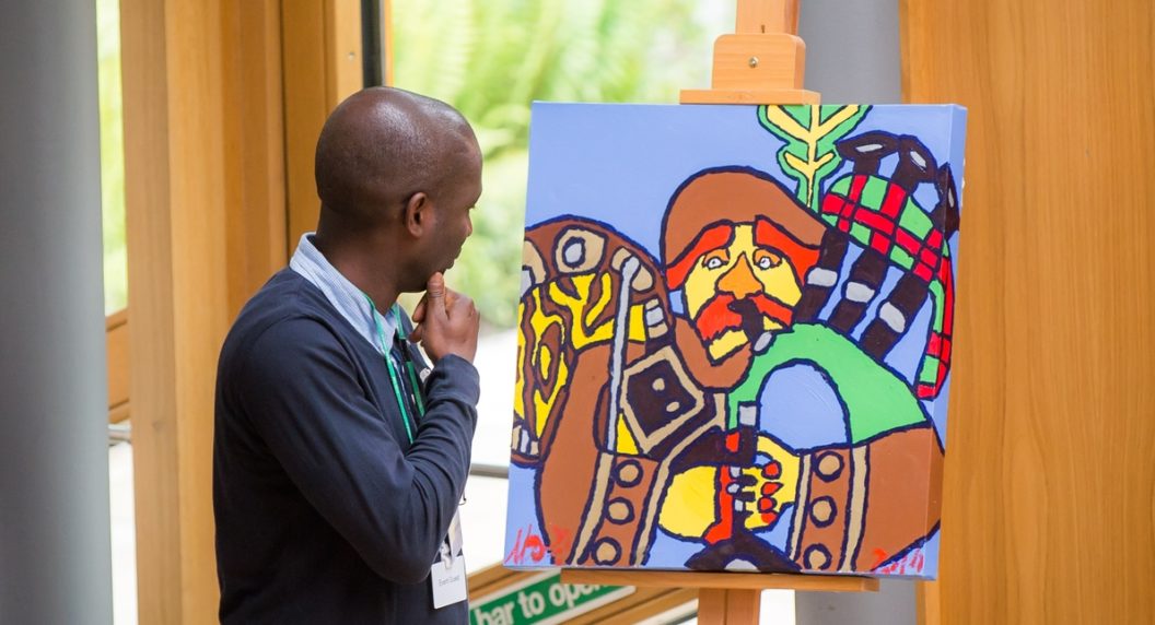 person looking at the IASSIDD artwork on display