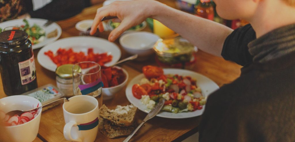 table full of healthy food and person eating