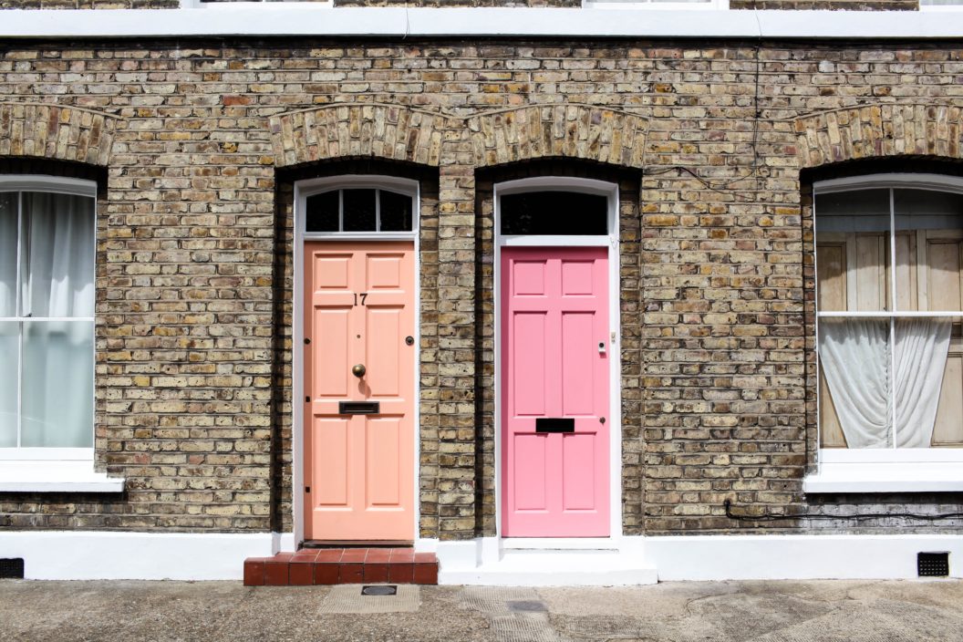 terrace houses one with an orange door and one with a pink door