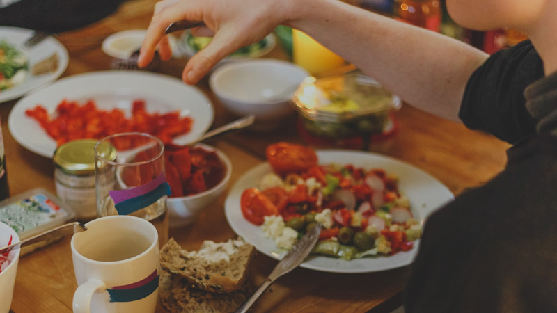 Scottish Commission for Learning Disability - man eating his dinner on a table with lots of vegetables and salad