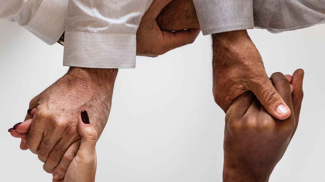 Hands of people from different races, ages and genders joined together