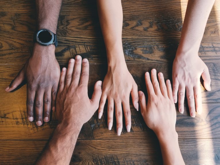 different people's hands side by side on a table