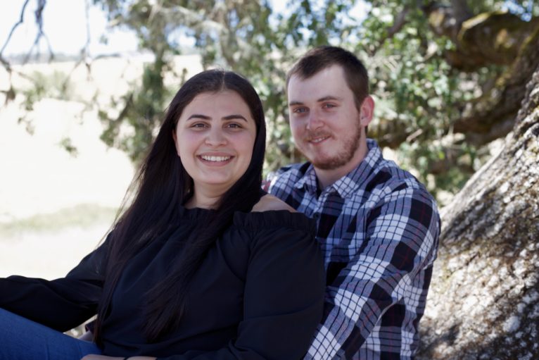 A man and woman smile and sit together