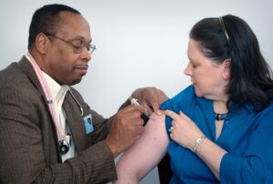 A doctor gives a woman a vaccination. Photo by CDC on Unsplash.
