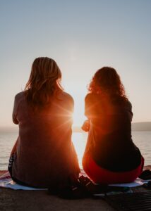 Two women sit in the sunset