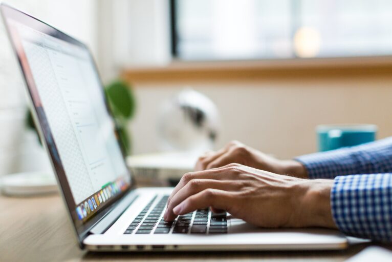 A person types on a laptop