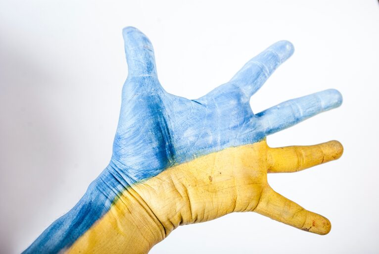 Outstretched hand painted in the blue and yellow of Ukrainian flag