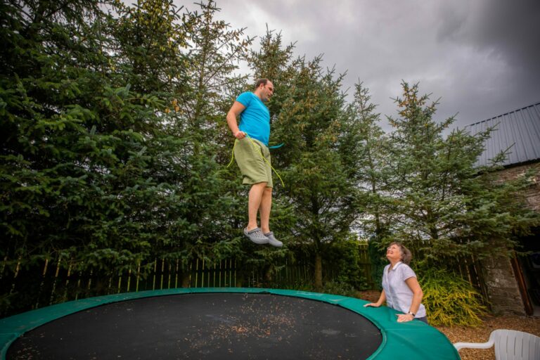 Louis jumps on a trampoline, as his mother Kate looks on